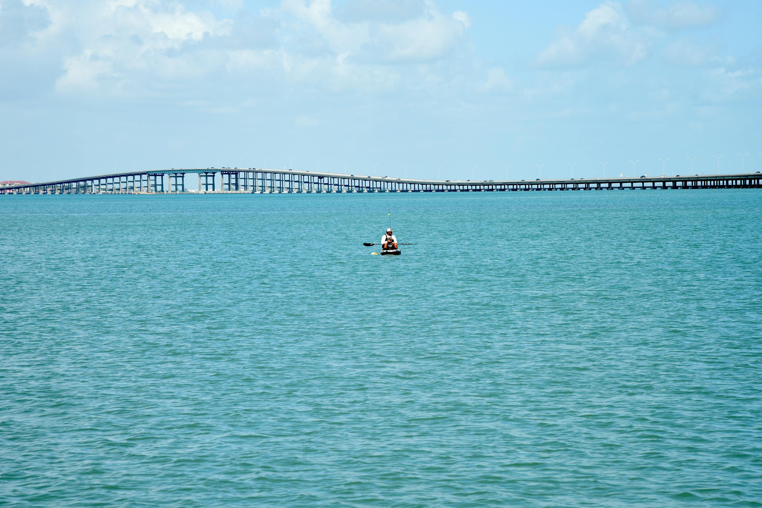 A peaceful day canoeing on the sea with a bridge in the background at South Padre Island, Texas.